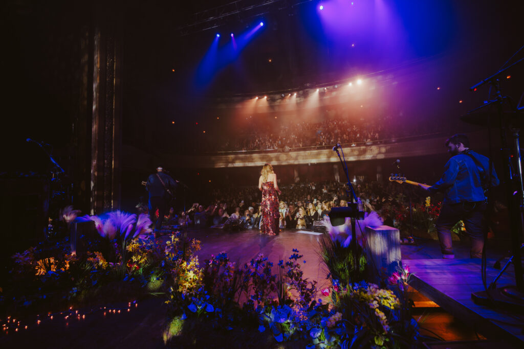 Carly Pearce standing on stage in front of fans during her hummingbird world tour