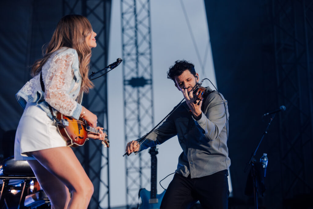 carly pearce and band member jon playing on stage